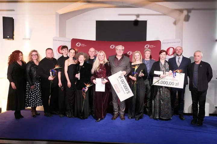 fot. Dariusz Gorajski / Kurier Szczeciński Zdjęcie z gali rozdania Bursztynowych Pierścieni. Na niebieskim dywanie pozuje grupa elegancko ubranych osób.