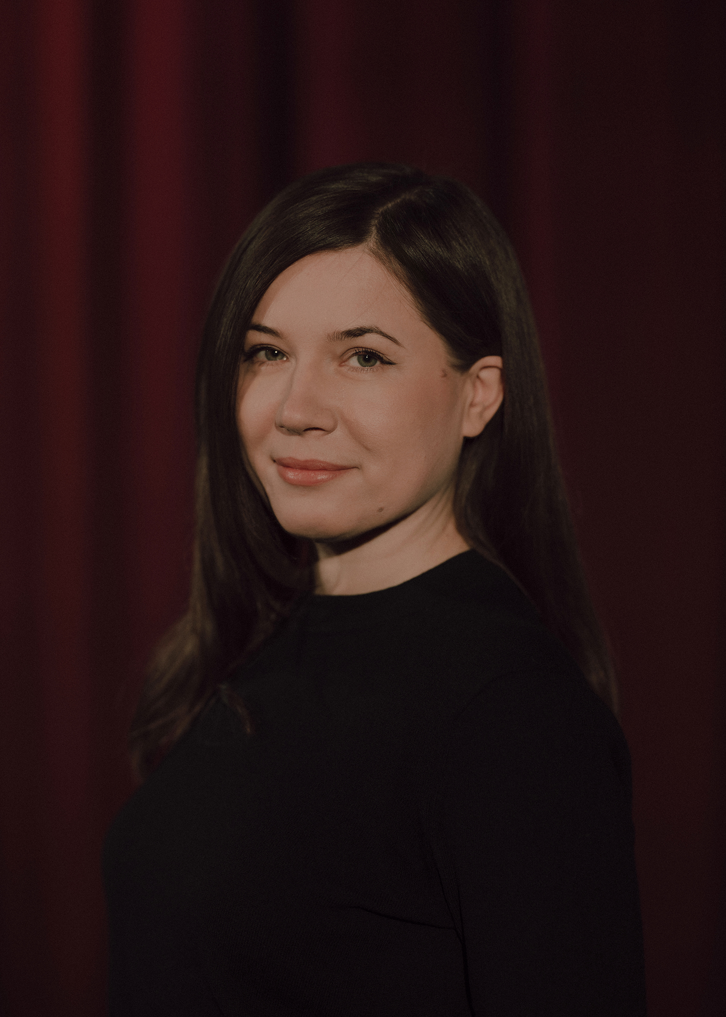 fot. Karolina Jóźwiak Portret aktorki na tle czerwonej kotary.