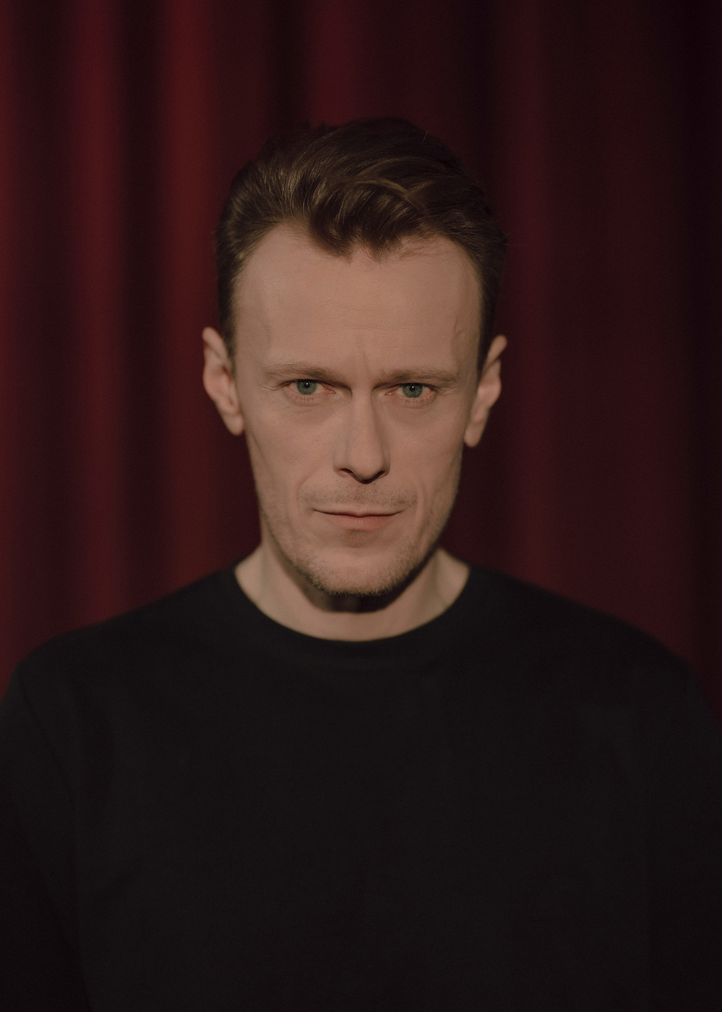 fot. Karolina Jóźwiak Portret aktora, w tle czerwona kotara.
