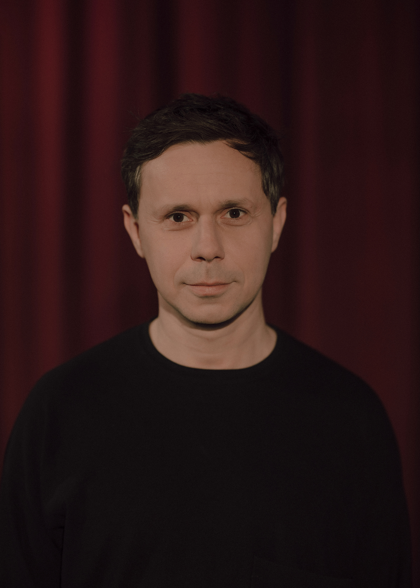 fot. Karolina Jóźwiak Portret aktora, w tle czerwona kotara.