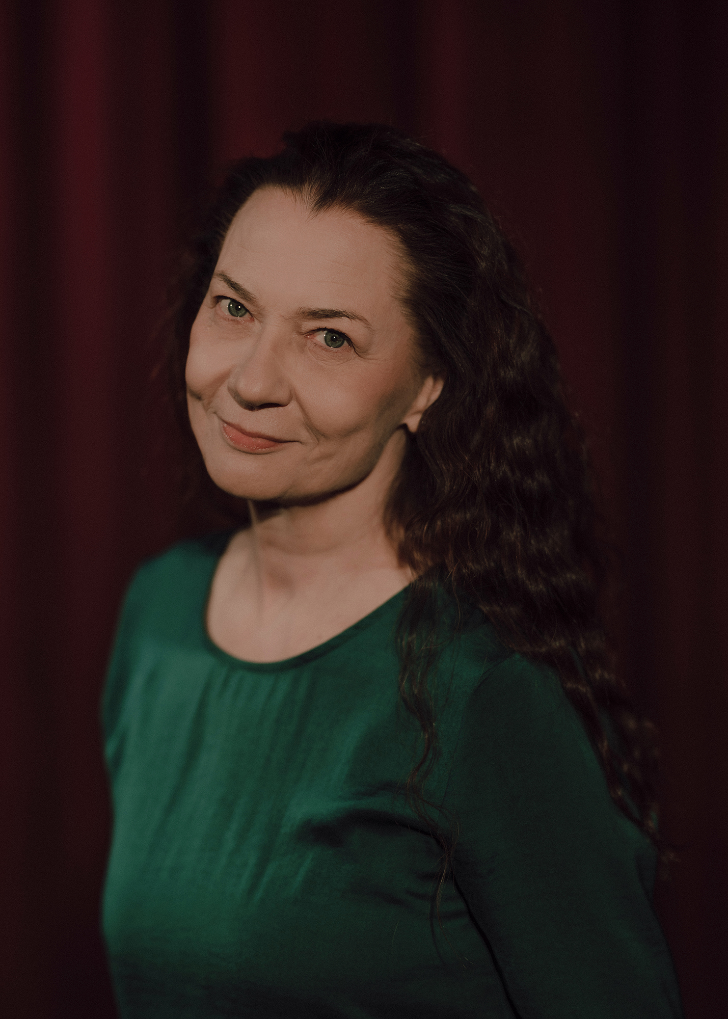 Portret aktorki, w tle czerwona kotara.