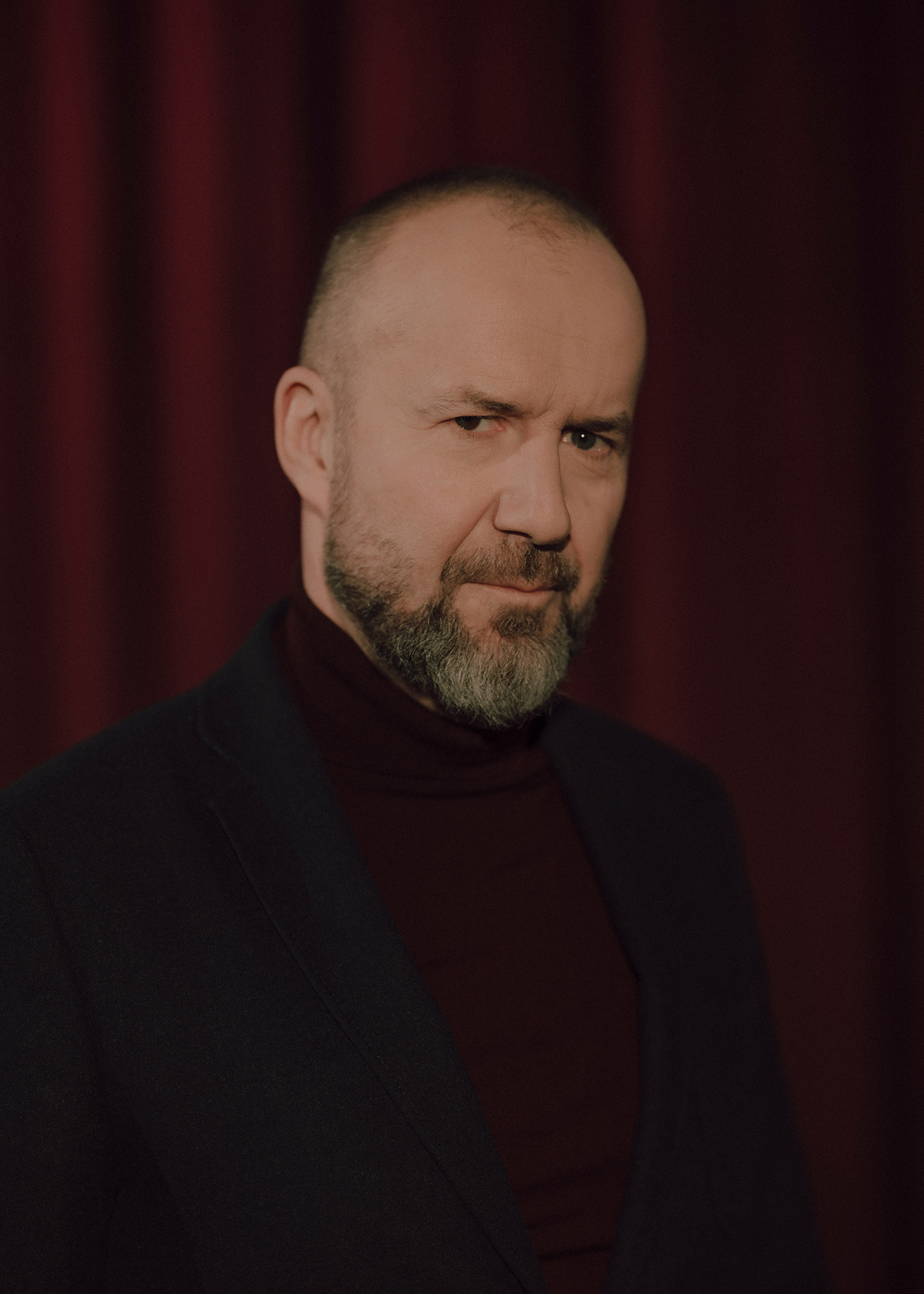 fot. Karolina Jóźwiak Portret aktora, w tle czerwona kotara.