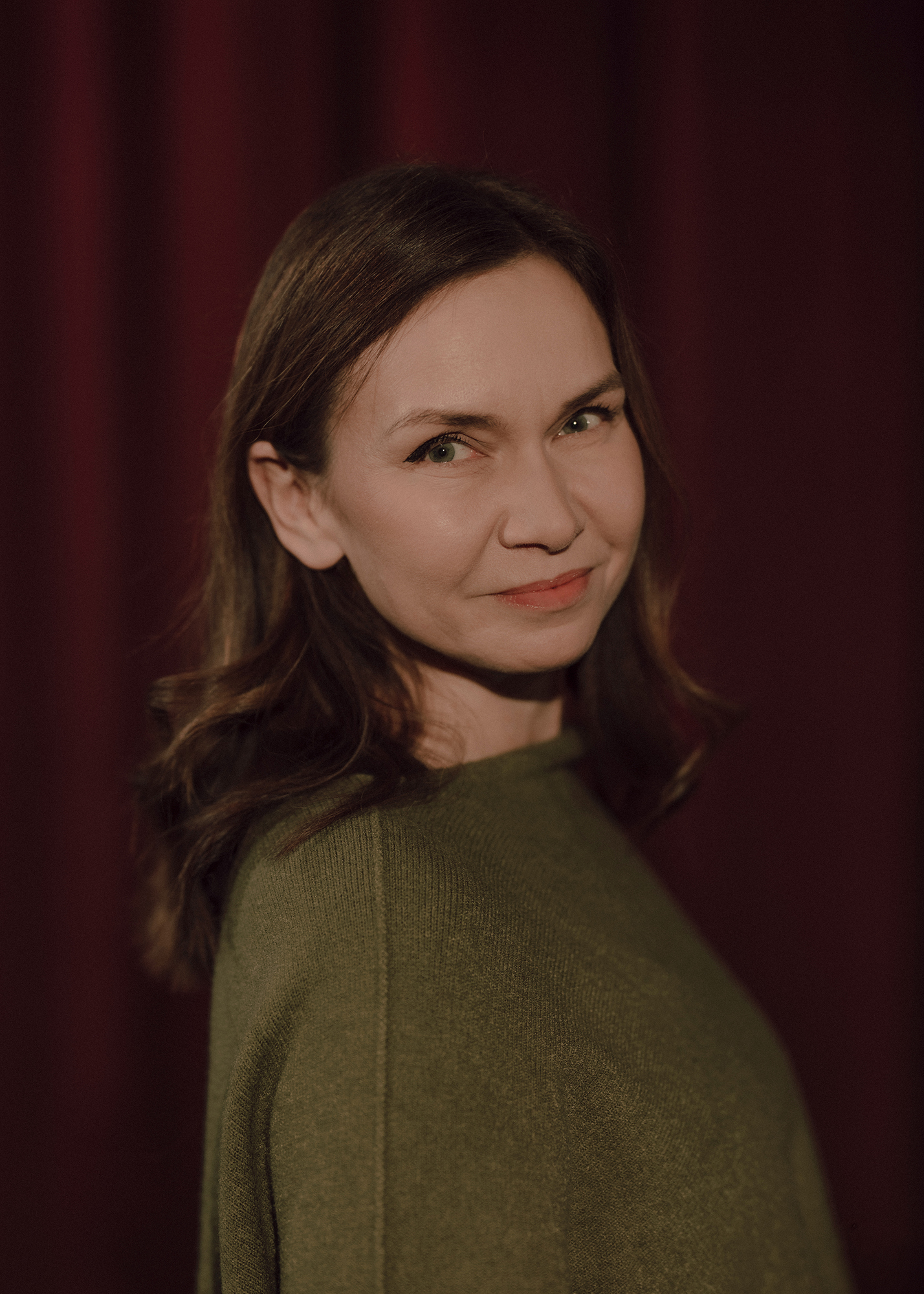 Portret aktorki, w tle czerwona kotara.