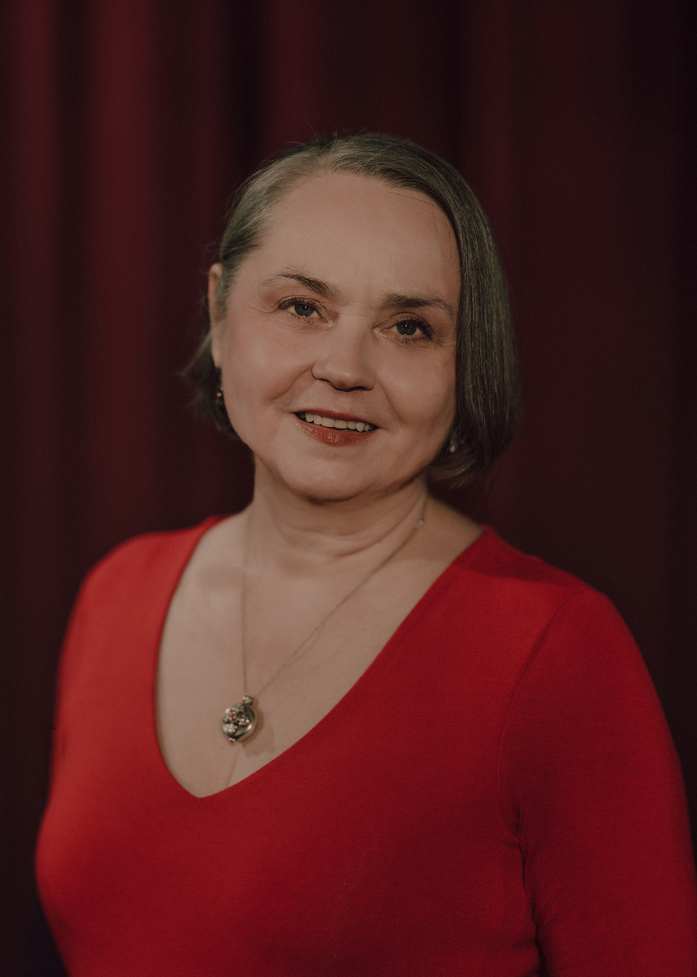 Portret aktorki, w tle czerwona kotara.
