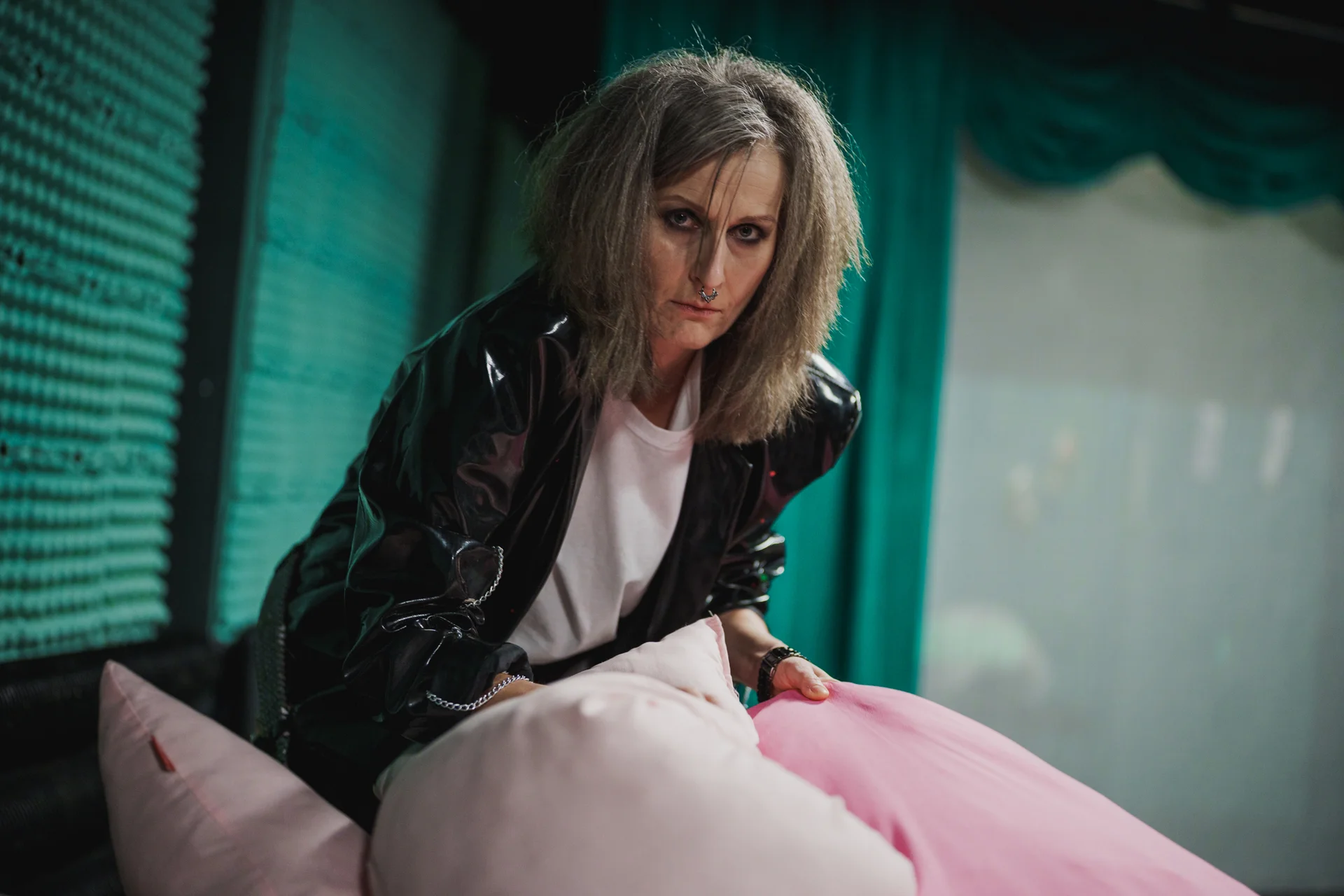 Aktorka w ciemnym makijażu i czarnej skórzanej kurtce. 