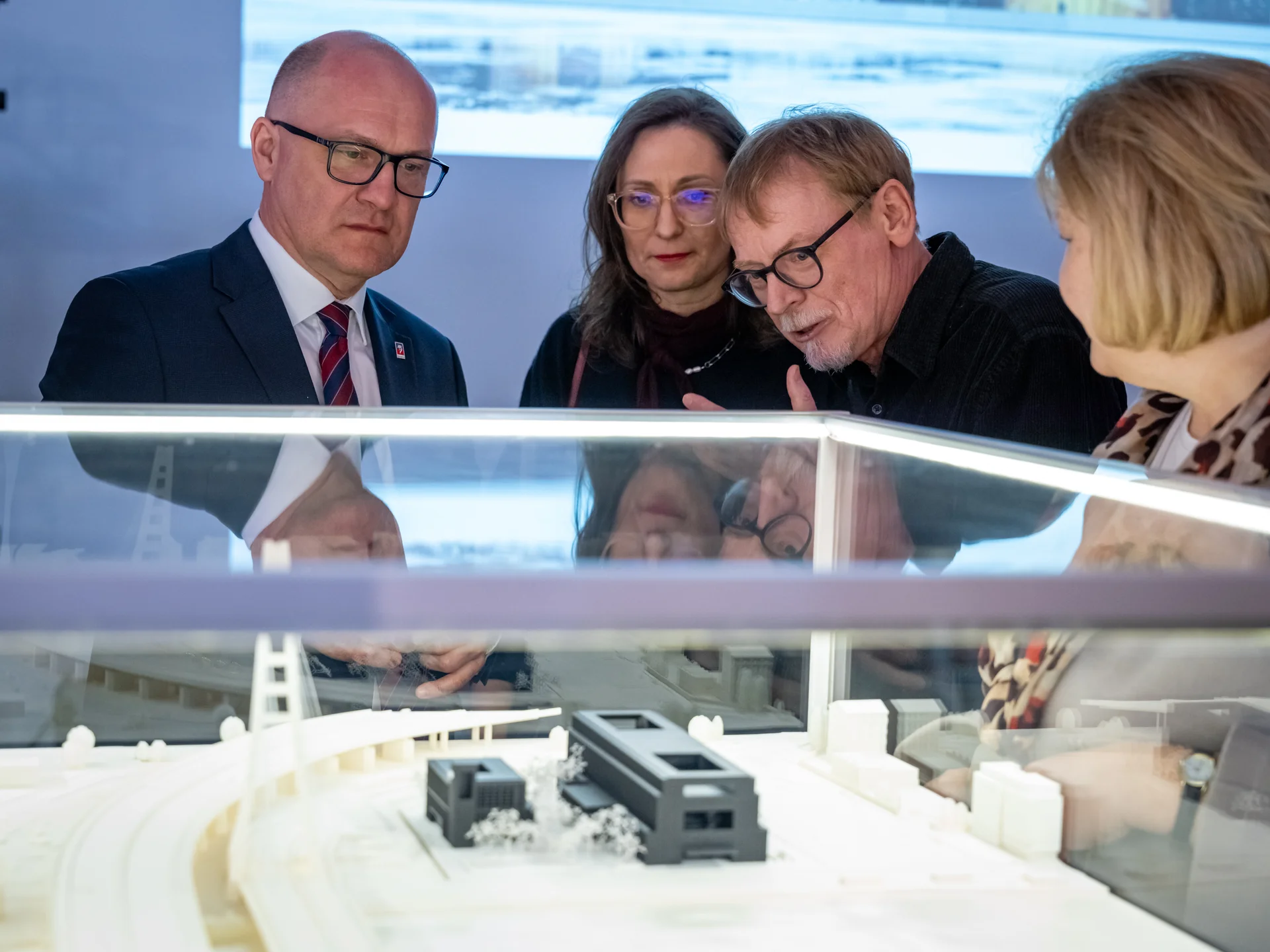 Prezydent miasta Piotr Krzystek i dyrektor Mirosław Gawęda pochylają się nad szklaną gablotą. W środku makieta nowego teatru. 