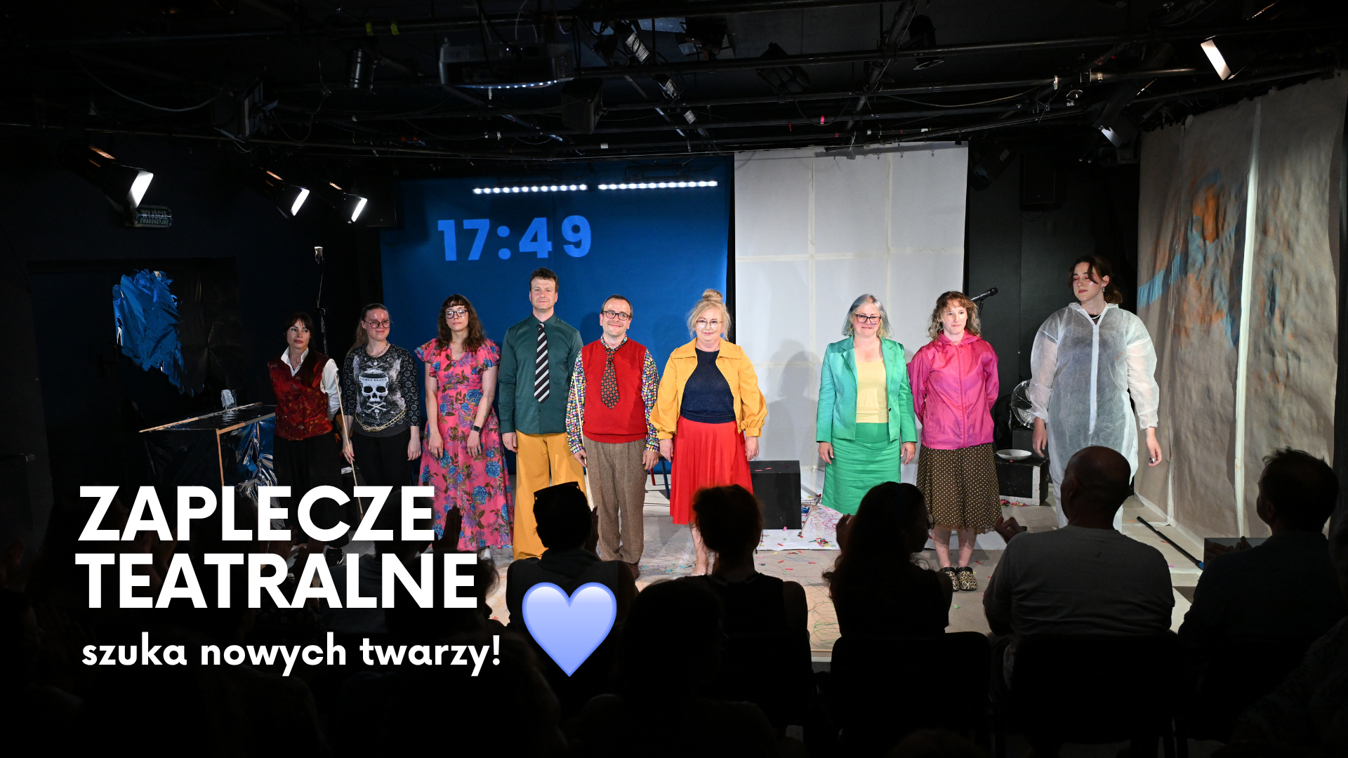 Fot. Marcin Bielecki Zdjęcie przedstawia grupę ludzi w kolorowych ubraniach na scenie. Na zdjęciu jest napis - Zaplecze Teatralne szuka nowych twarzy.